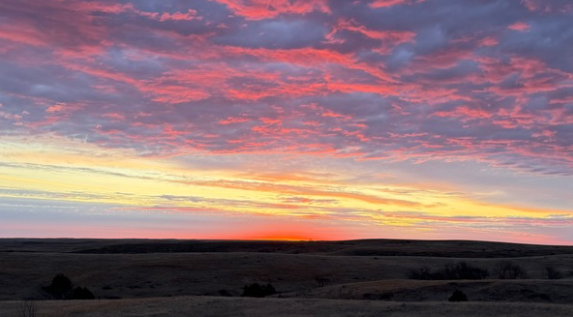 Sunset over a landscape with pink and orange clouds